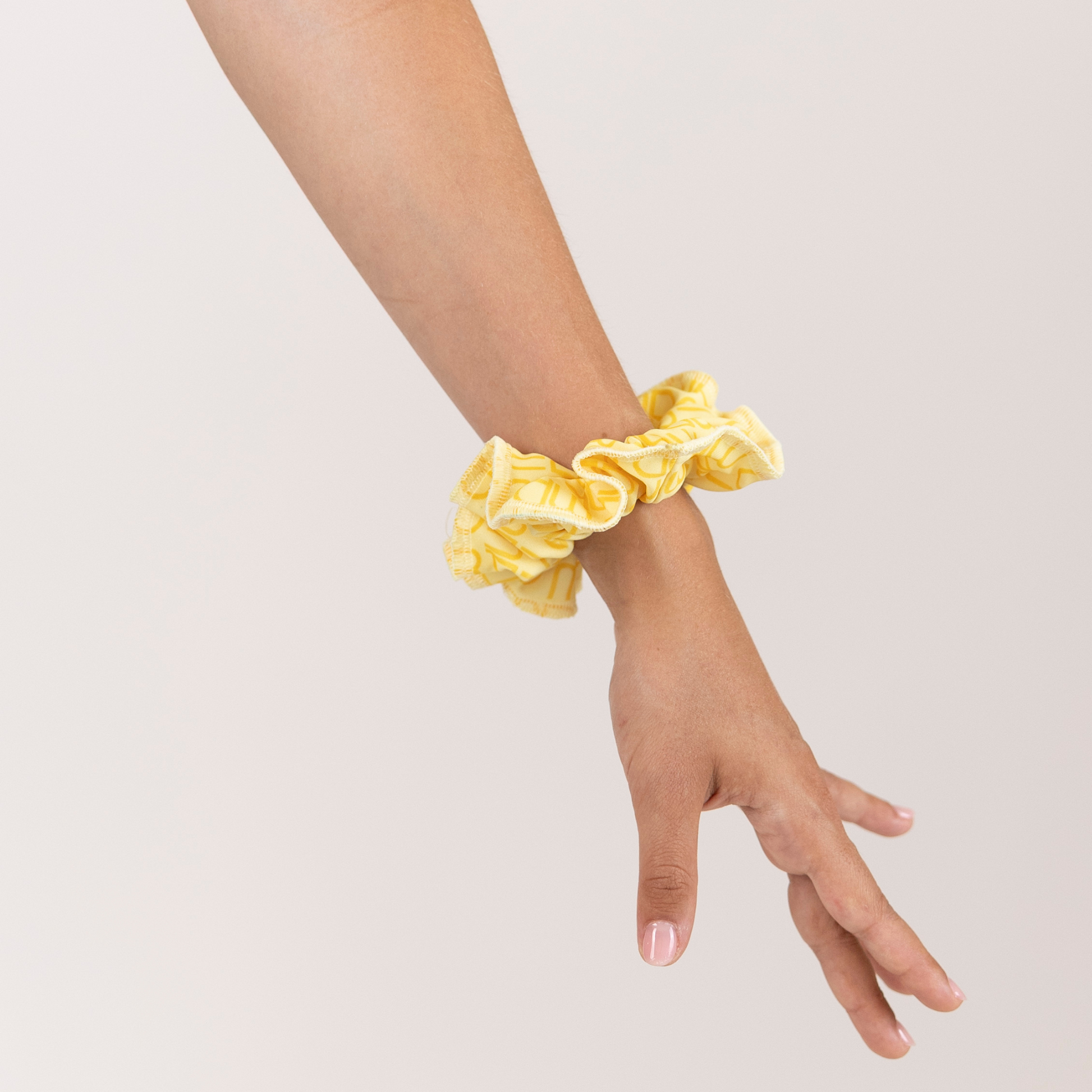 Girl with Butter Yellow Loop Scrunchie on wrist.
